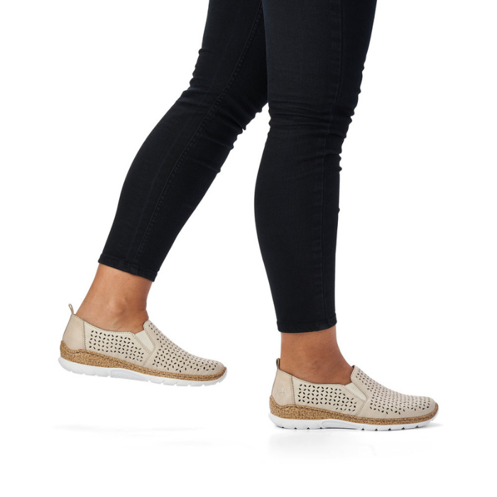 Beige slip-on shoes worn with black leggings.