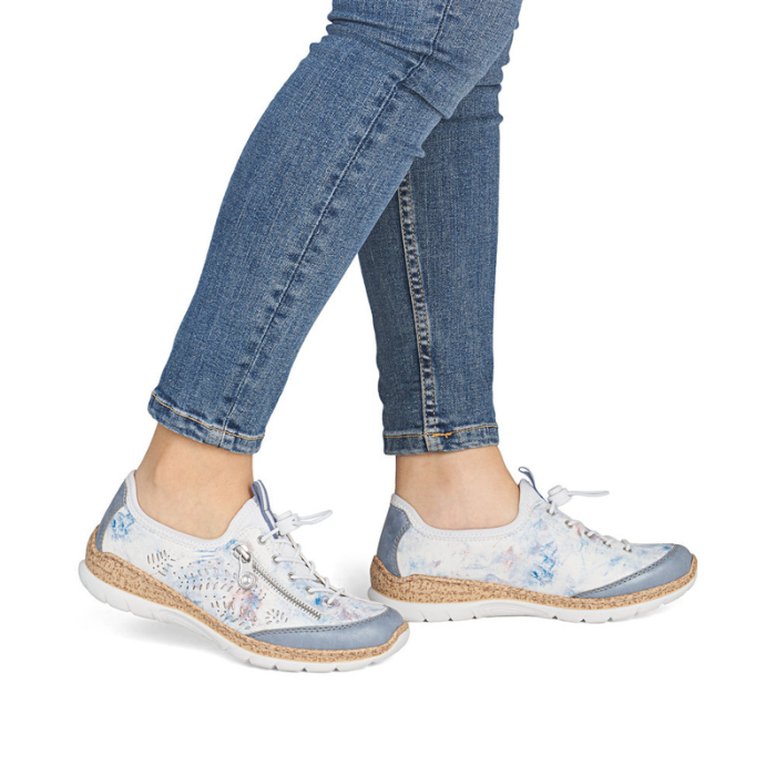 White sneakers with blue accents worn with blue jeans.