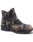A single ankle boot with a dark charcoal gray base and a beige floral pattern, featuring a side zipper and a low block heel.