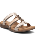 Women's Taos Prize 4 Slide Sandal in beige with three decorative metal medallions and cushioned footbed for arch and metatarsal support.