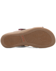 Beige rubber outsole with leaf pattern tread and orange Taos logo stamped in middle.