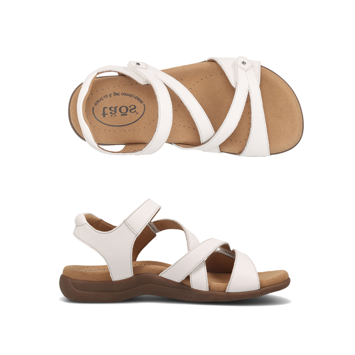 Pair of White backstrap sandals with two Velcro cross straps, tan Taos logo'd footbed and dark brown outsole.