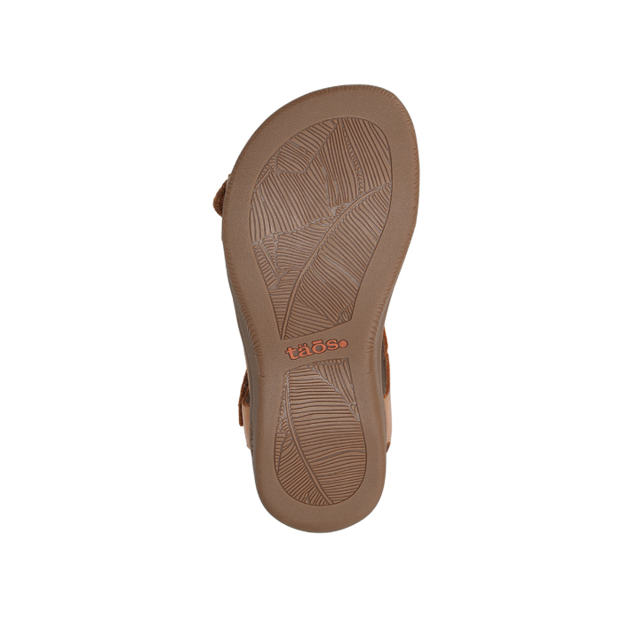 Leaf patterned tread on sandal's rubber outsole with orange Taos logo in middle.