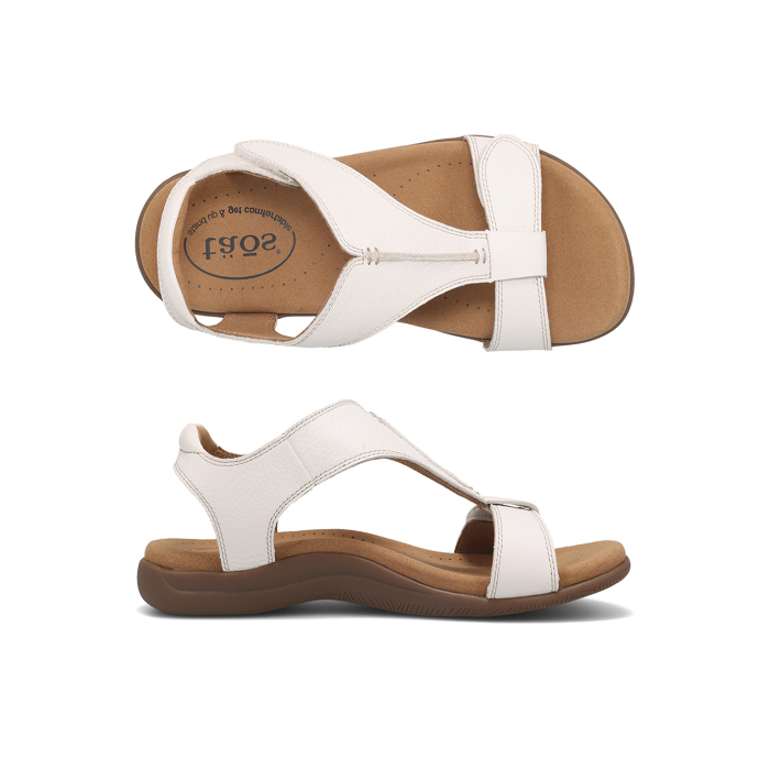 Pair of Backstrap leather sandals in white with two adjustable Velcro straps, t-strap design, tan Taos logo'd footbed and brown rubber outsole.