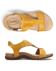 Pair of Yellow backstrap sandals with woven details on t-strap, tan Taos logo'd footbed and brown rubber outsole.