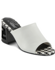  A pair of white open toe leather block heel sandals with a black and white checkered footbed. The black block heel has chunky "Z" shaped cut out.