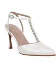White high-heeled pump with embellished t-strap, buckle ankle strap and tan Naturalizer logo'd footbed.