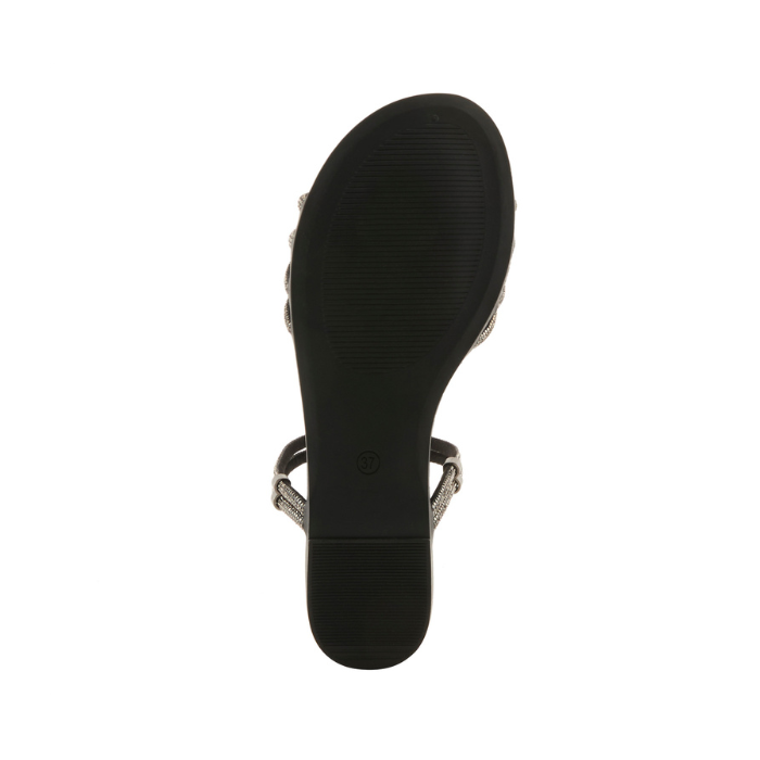 Light treaded black outsole of sparkly slide sandal.