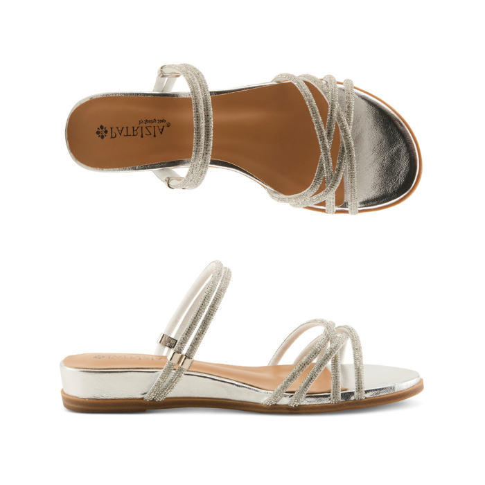Pair of Silver sparkly slide sandal with multiple criss-crossing straps, tan Patrizia logo'd footbed and low silver wedge outsole.