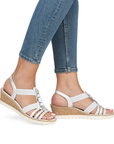 Silver gladiator inspired wedge sandals worn with blue jeans.