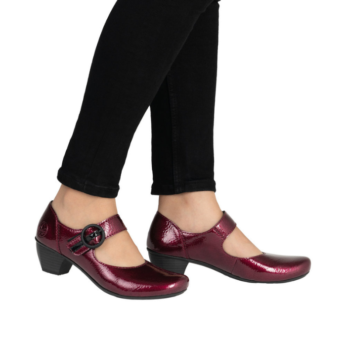 Burgundy shoes with a black buckle worn with black pants.