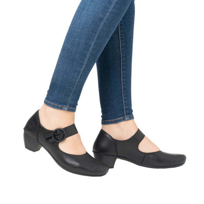Black shoes with a buckle worn with blue jeans.