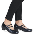 Dark navy patent Mary-jane low heel shoes worn with black pants.