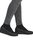 Black slip-on low wedge shoes worn with gray jeans.