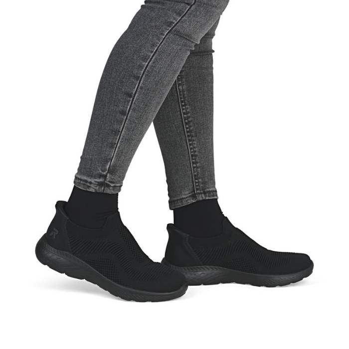 Black slip-on shoes worn with gray jeans.