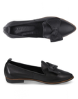 A pair of black leather flats with a pointed toe and slight lifted heel, Bueno logo'd footbed and a decorative large bow on the vamp.