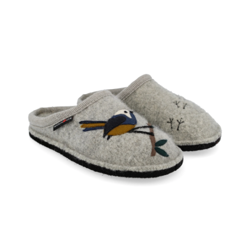 A pair of light gray felt slip-on slippers with embroidered bird with blue, yellow, and white details on a branch on one slipper, while the other has small black stitched bird footprints.