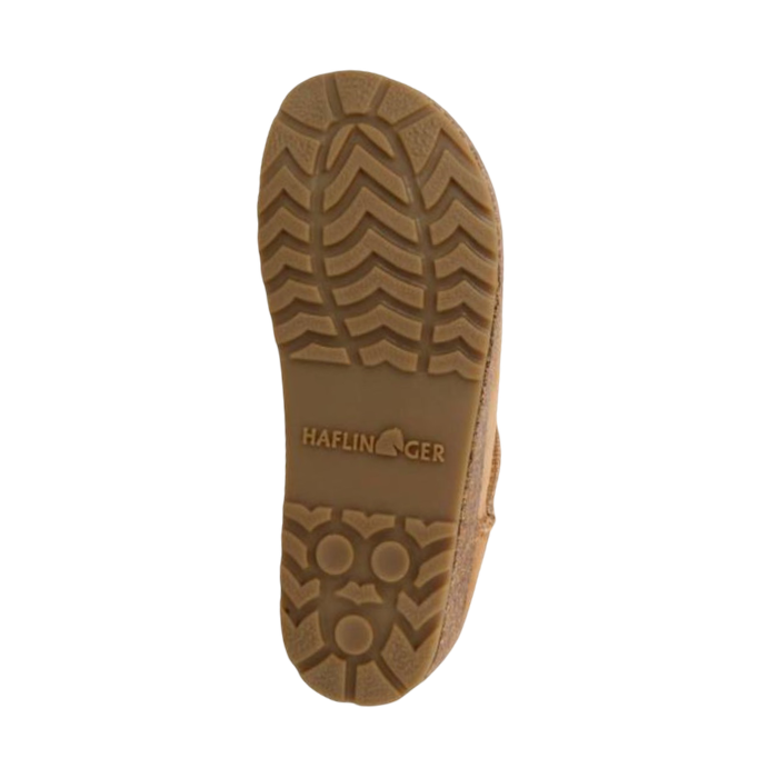 Tan treaded outsole of ankle boot with Haflinger logo stamped in middle.
