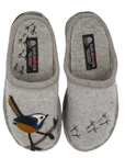 A pair of light gray felt slip-on slippers with embroidered bird with blue, yellow, and white details on a branch with bird footprints over the footbed on one slipper, while the other has small black stitched bird footprints.