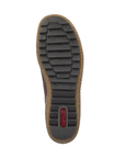 Top-down view of a shoe sole showing a black treaded outsole with a tan cork-like midlayer and a small red Rieker logo near the heel, on a white background.