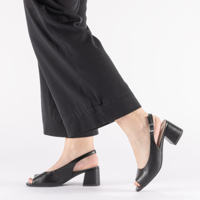 Black open toe slingback heels worn with black pants.