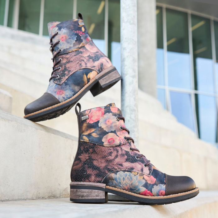 Floral patterned combat boots with blurred steps to a building in background.