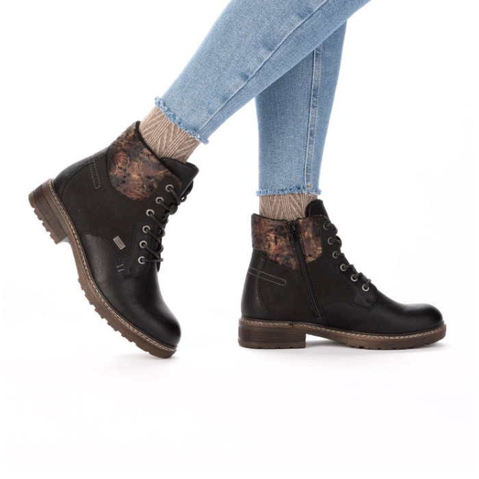 Black lace-up boots worn with light blue jeans and patterned tan socks.