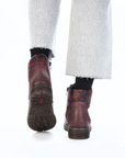 Red leather boots worn with white pants.