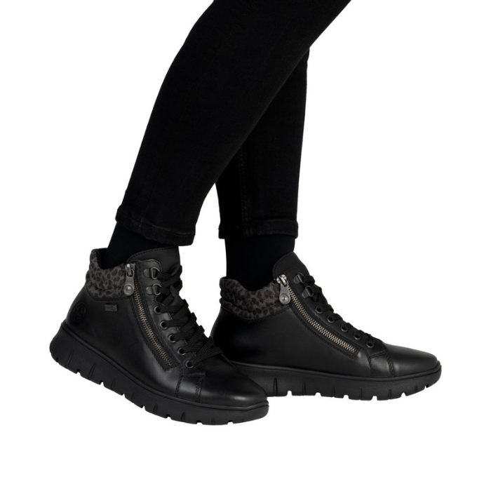 Black high-top sneakers with leopard print accents worn with black pants.