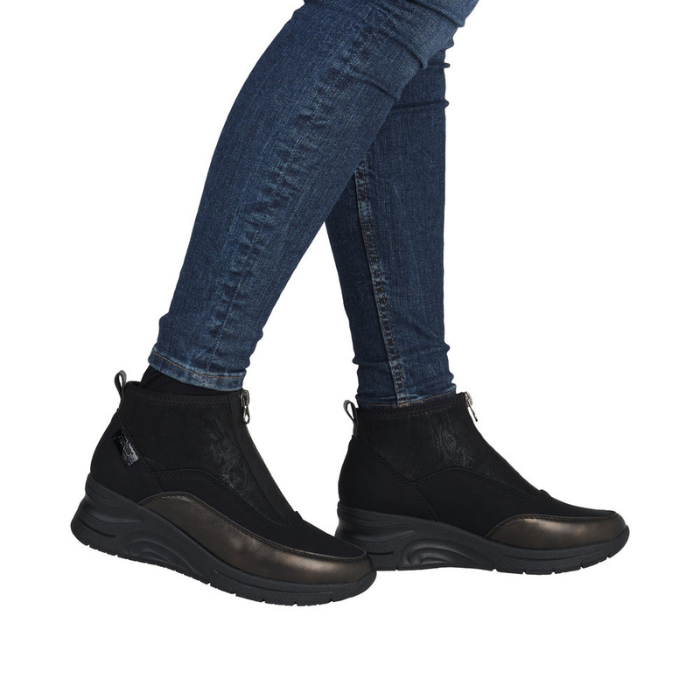 Black ankle boots worn with blue jeans.