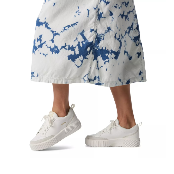 White sneakers worn with a white with  blue tie-dye skirt.