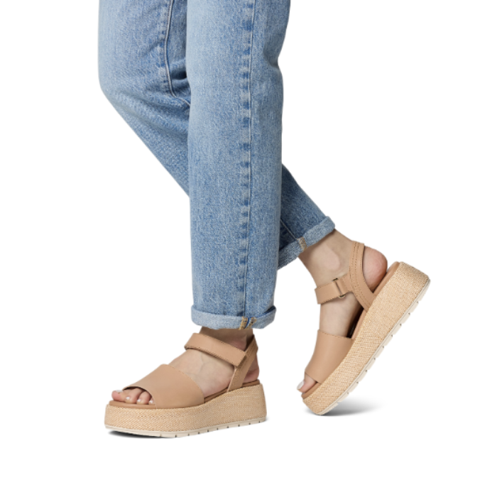 Tan platform sandals worn with blue jeans.