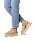 Tan platform sandals worn with blue jeans.