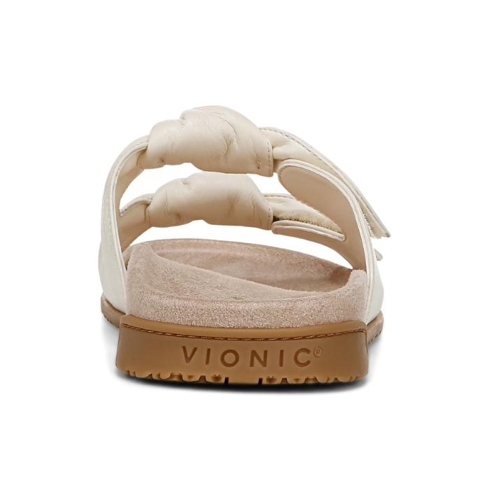 Vionic  logoo'd heel of sandal with white strap and brown outsole.