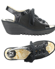 Pair of Black suede wedge sandal with thick laces, peep toe, patent accents, yellow patterned footbed with FLY London logo and a lugged rubber outsole.