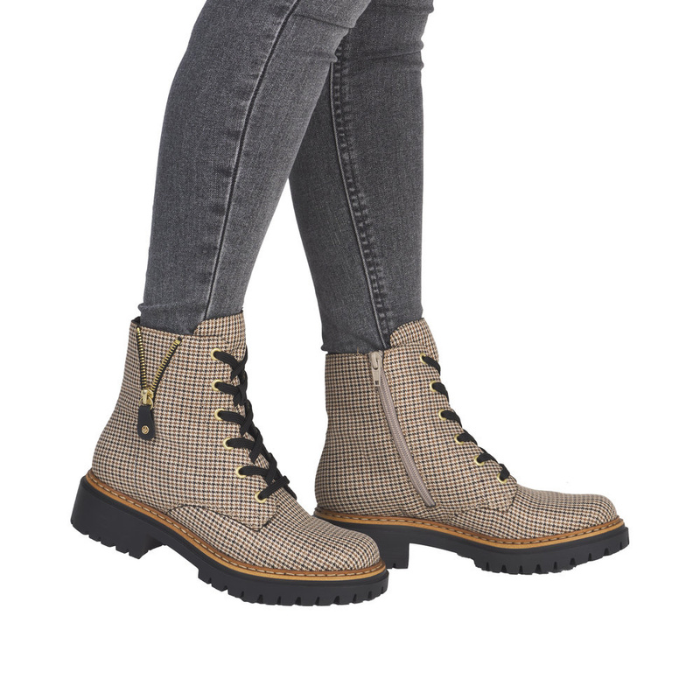 Beige houndstooth patterned combat boots with black jeans. 