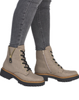 Beige houndstooth patterned combat boots with black jeans. 