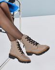 Beige houndstooth patterned combat boots with nylons and blue skirt.