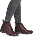Maroon boots with black accents worn with gray jeans.