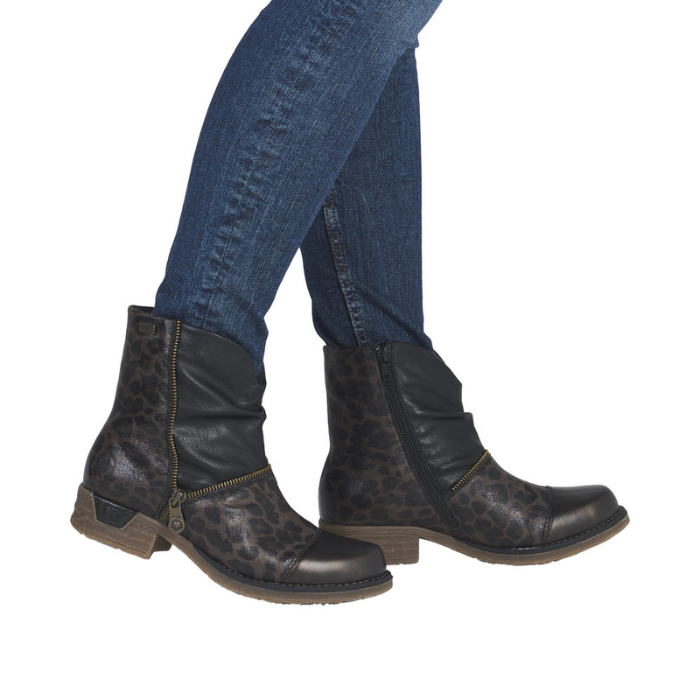 Woman in blue jeans wearing black leopard ankle boots with accent faux zipper.