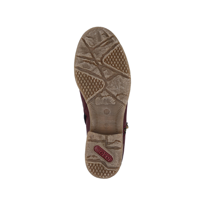 Brown treaded outsole of red ankle boot with red Rieker logo on heel.