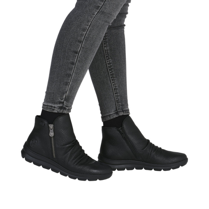 Black ankle boots worn with gray jeans.