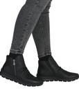 Black ankle boots worn with gray jeans.