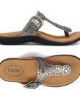 Silver T-strap sandal with embroidery, rivets and grommet detailing and an antiqued adjustable buckle with beige footbed and black outsole.