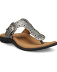 Silver T-strap sandal with embroidery, rivets and grommet detailing and an antiqued adjustable buckle with beige footbed and black outsole.