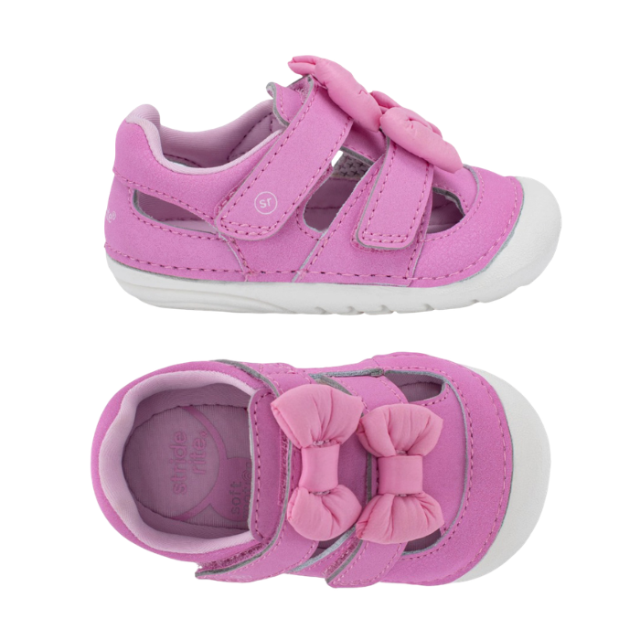 Pair pink toddler sandals with two hook-and-loop straps, a large matching bow on the toe and white soft bottom outsole.