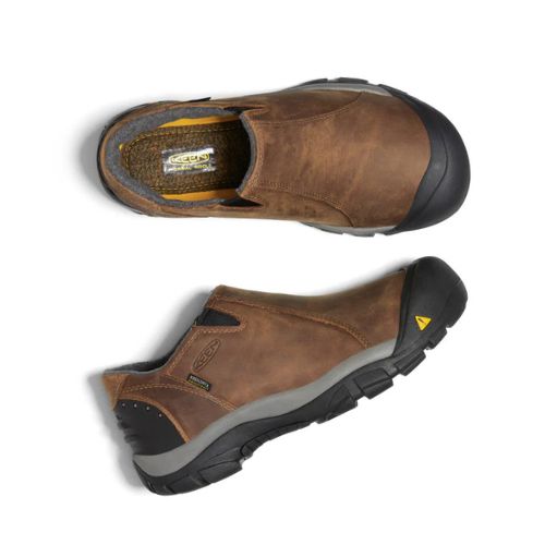 Pair of Brown leather slip-on shoes with black rubber heel and toe bumper connected to the black rubber outsole.