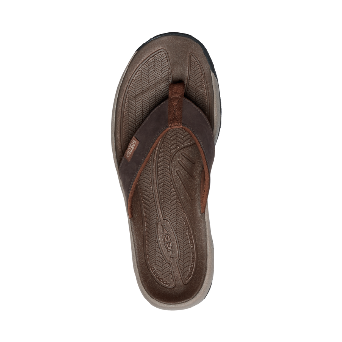 Brown thong sandal with brown textured footbed and black rugged outsole. 