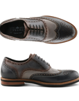 Pair of Gray, navy and black oxford wingtip brogue shoes with laces, burnished finish, tan midsole and black outsole.