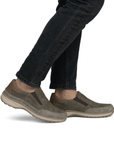 Brown slip-on shoes worn with black jeans.